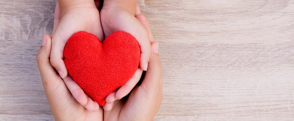 To hands holding a red heart