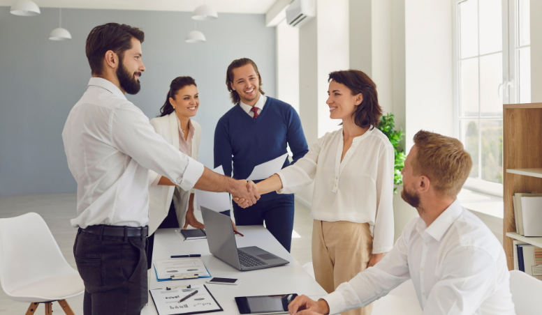 Group of coworkers in boardroom shaking hands