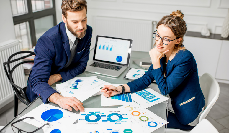 Two people reviewing charts and analytics